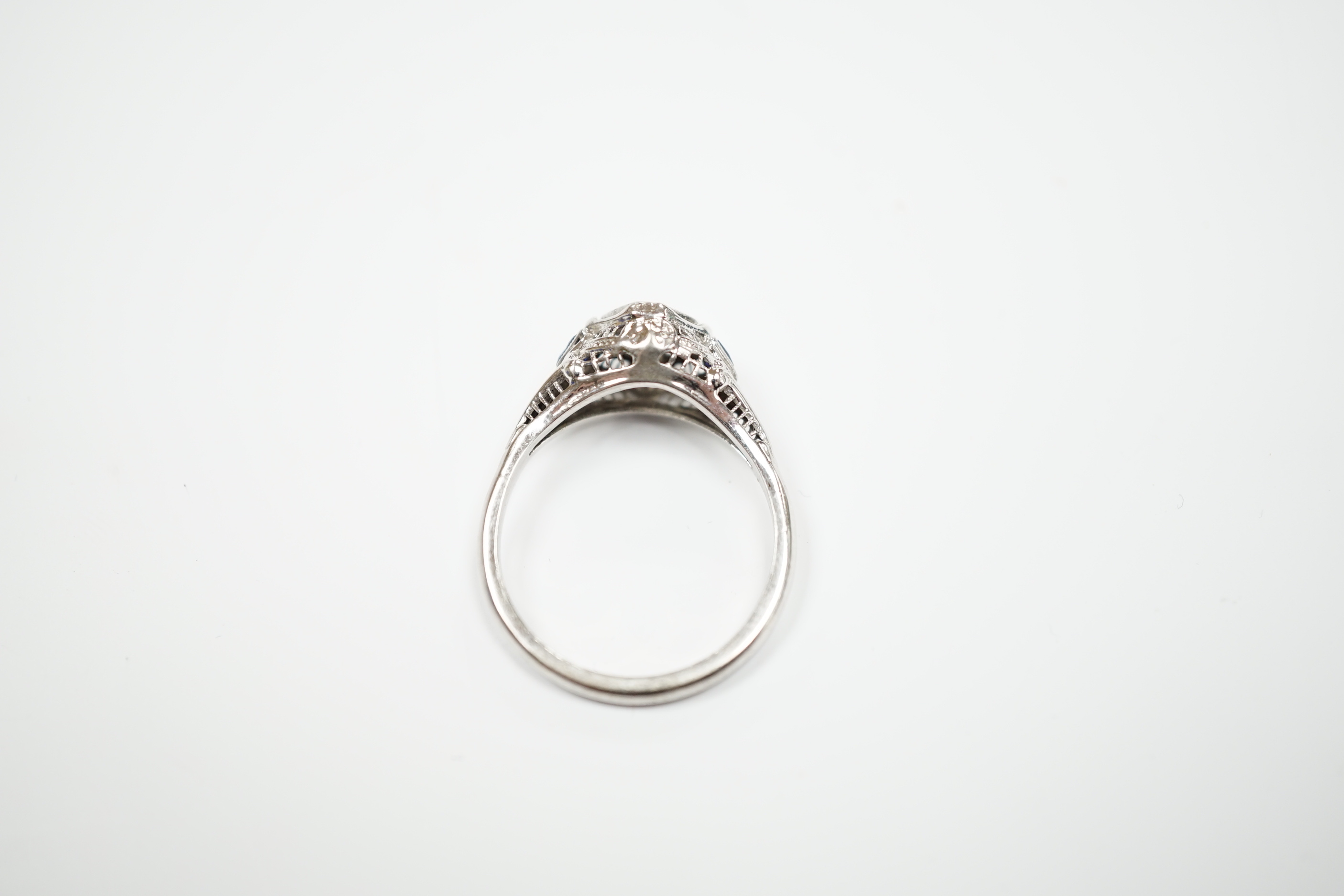 An 18ct and single stone diamond set ring, with two stone triangular sapphire set shoulders, size P, gross weight 3.1 grams.